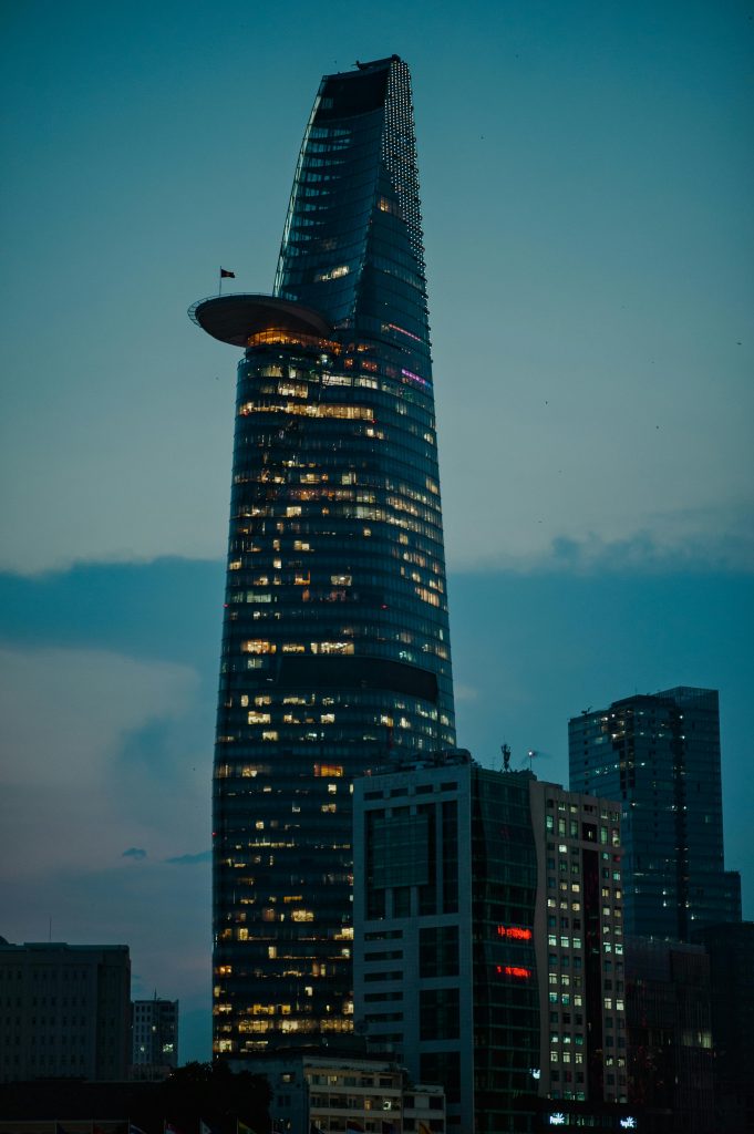 A stunning view of the Bitexco Financial Tower in Ho Chi Minh City at dusk, with city lights glowing.